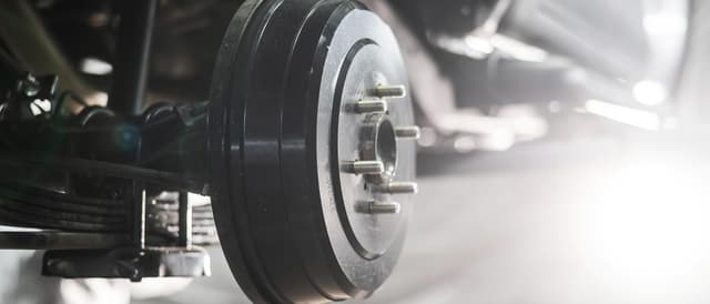 A drum brake uses friction material caused by a set of shoes or pads that press outward against a rotating cylinder-shaped part called a brake drum.